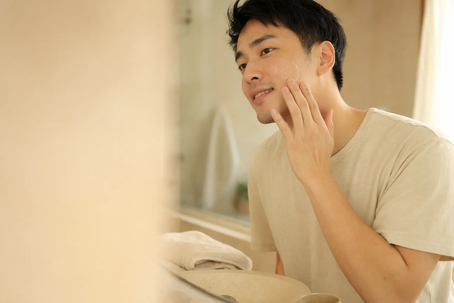A young man smoothing a clear Oxora gel onto his forearm in warm morning light